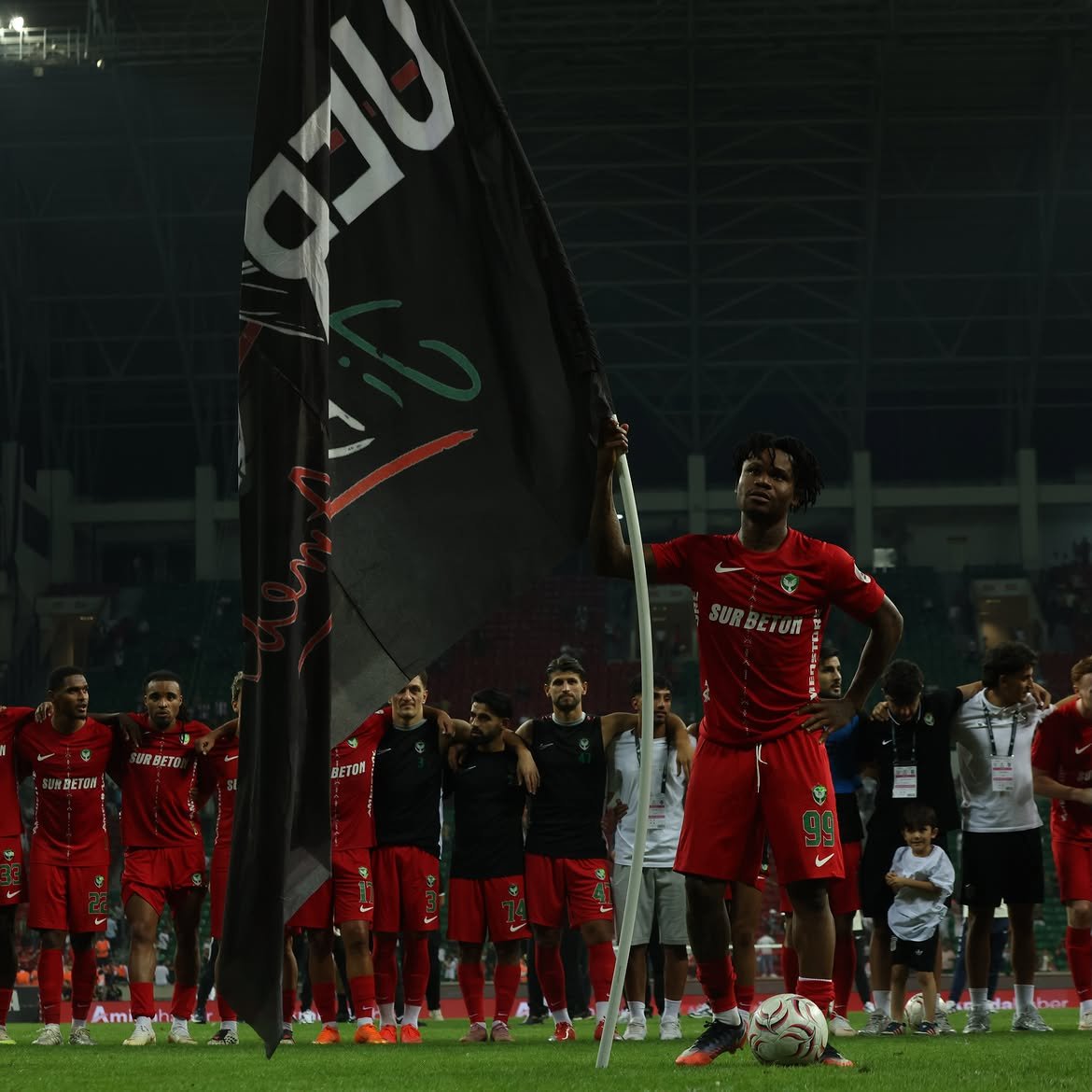 Gift Orban holding a flag with his team after the final whistle